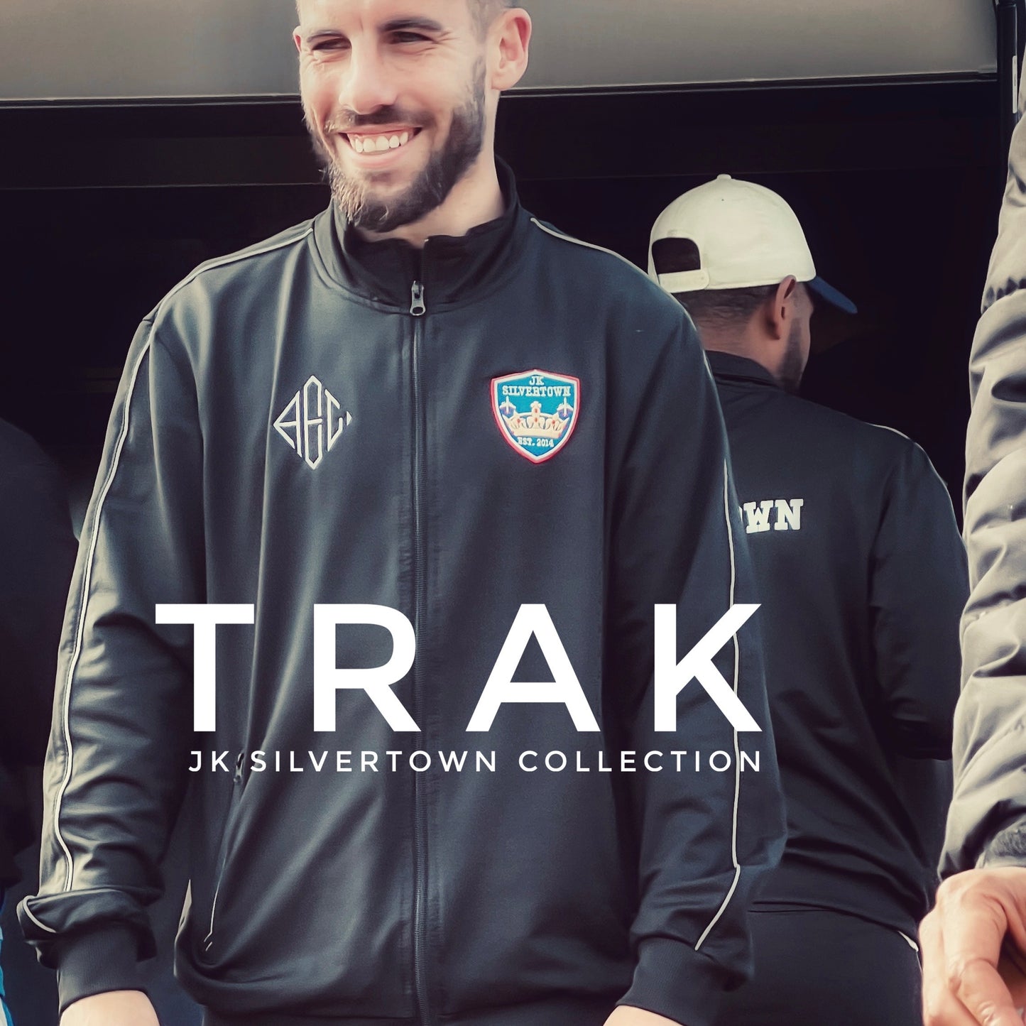 Man wearing 'TRAK' from 'JK Silvertown Collection' text.